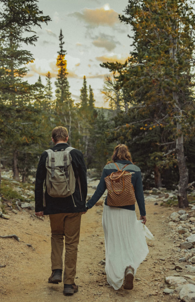 a couple holding hands on a hiking path 