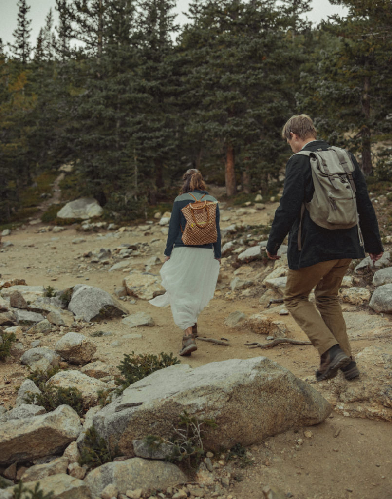 a couple hiking in their wedding attire to an elopement location in colorado