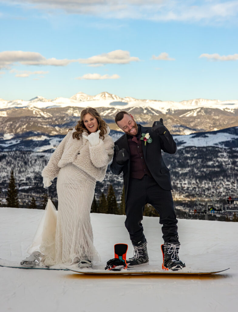 Couple getting married at a ski resort and snowboarding down the hill in wedding dress