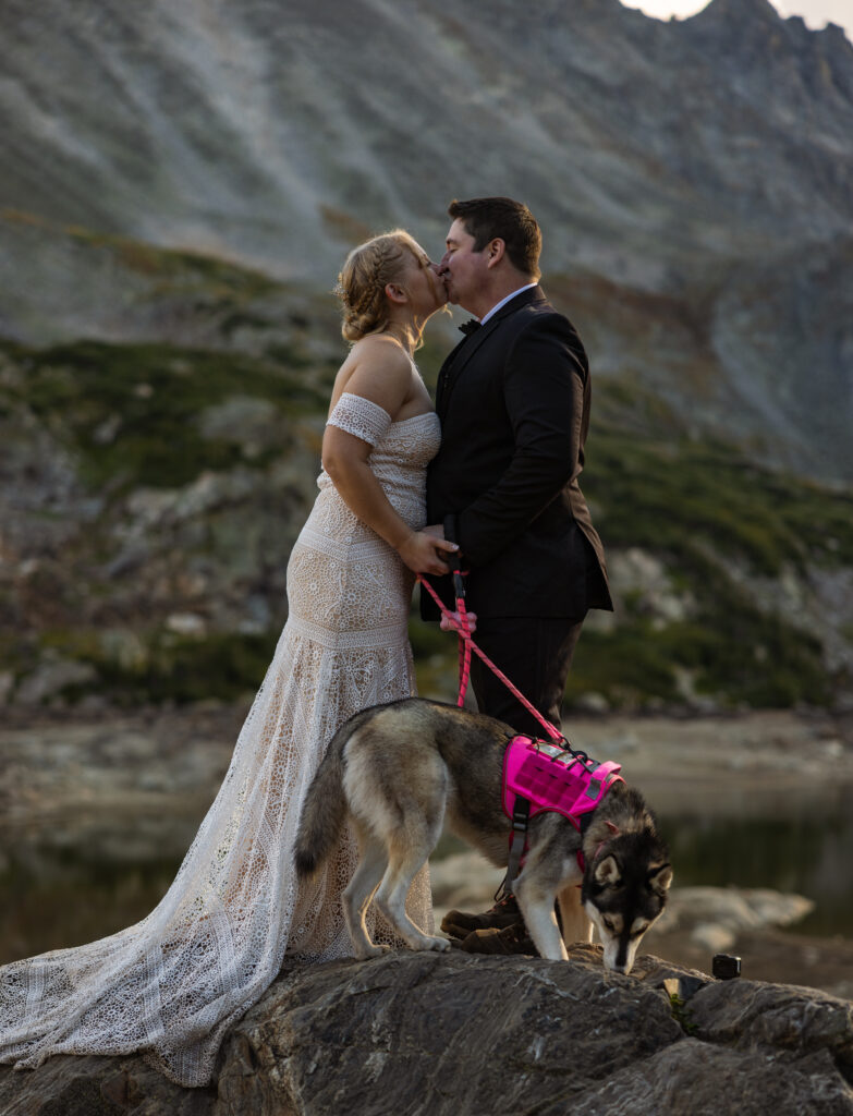 couple kissing on a rock in the mountains of colorado at lake isabelle