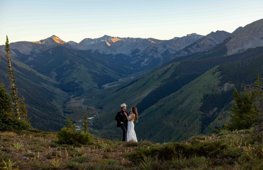 Wide-angle shot of the couple standing on a rocky overlook
