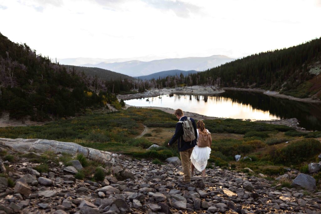 A breathtaking sunset view over St. Mary’s Glacier as the couple walks hand in hand.