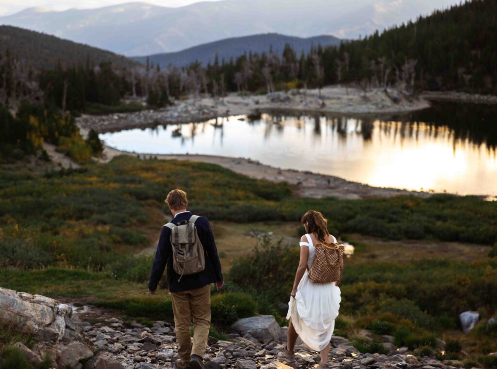 Bride’s dress flowing in the wind as she stands on the mountain trail.