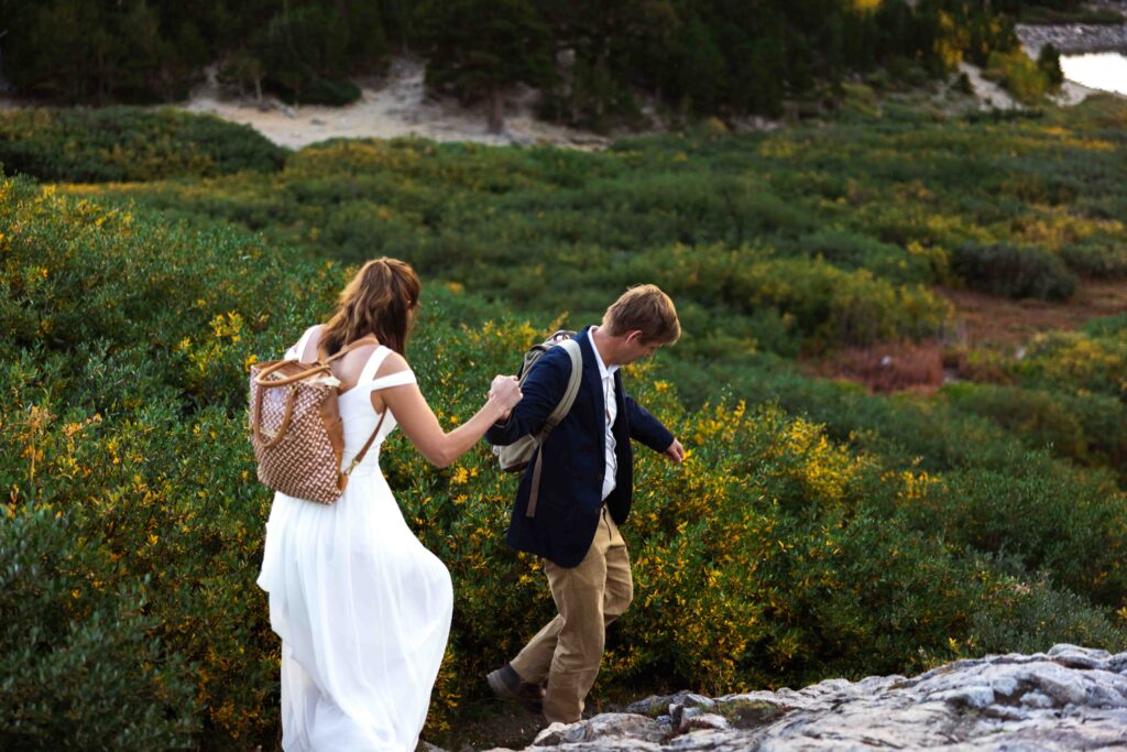 A joyful, candid shot of the couple running hand in hand down the mountain trail.