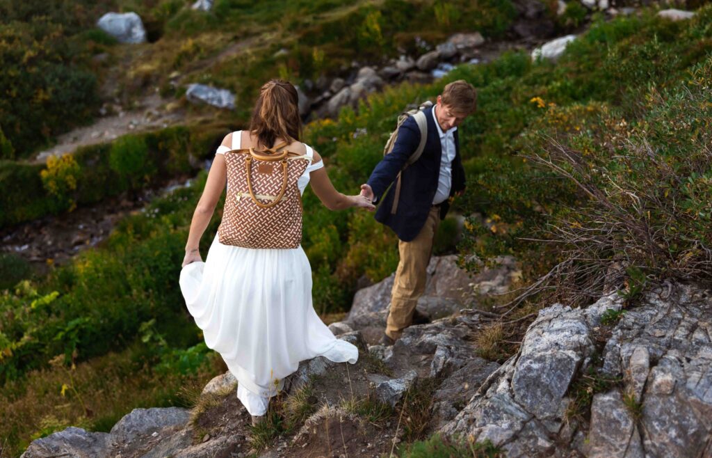 Couple sharing their first dance barefoot on a rocky ledge by the lake.
