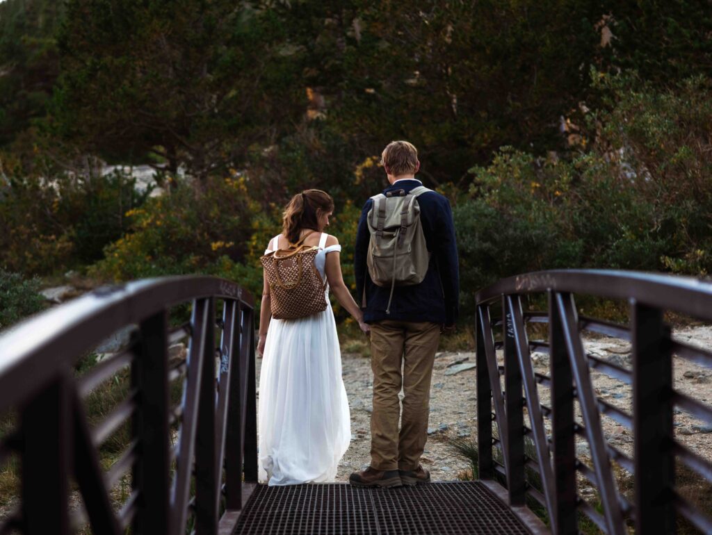 Soft, golden-hour light illuminating the couple as they share a quiet moment by the water.