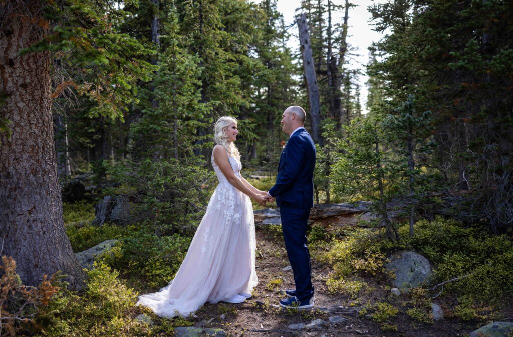 Couple embracing in a forested mountain setting.