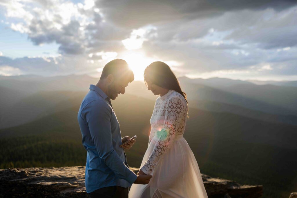 Bride and groom standing on the summit of Chief Mountain, exchanging vows with breathtaking mountain views.