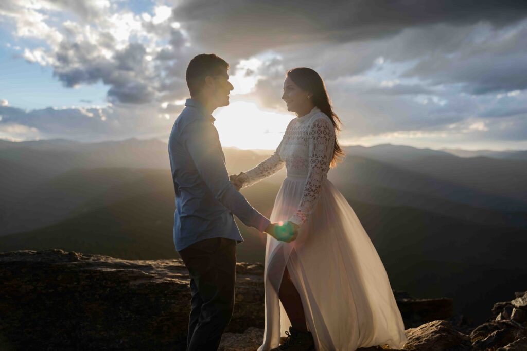 Bride adjusting her dress in the mountain breeze before saying “I do.”