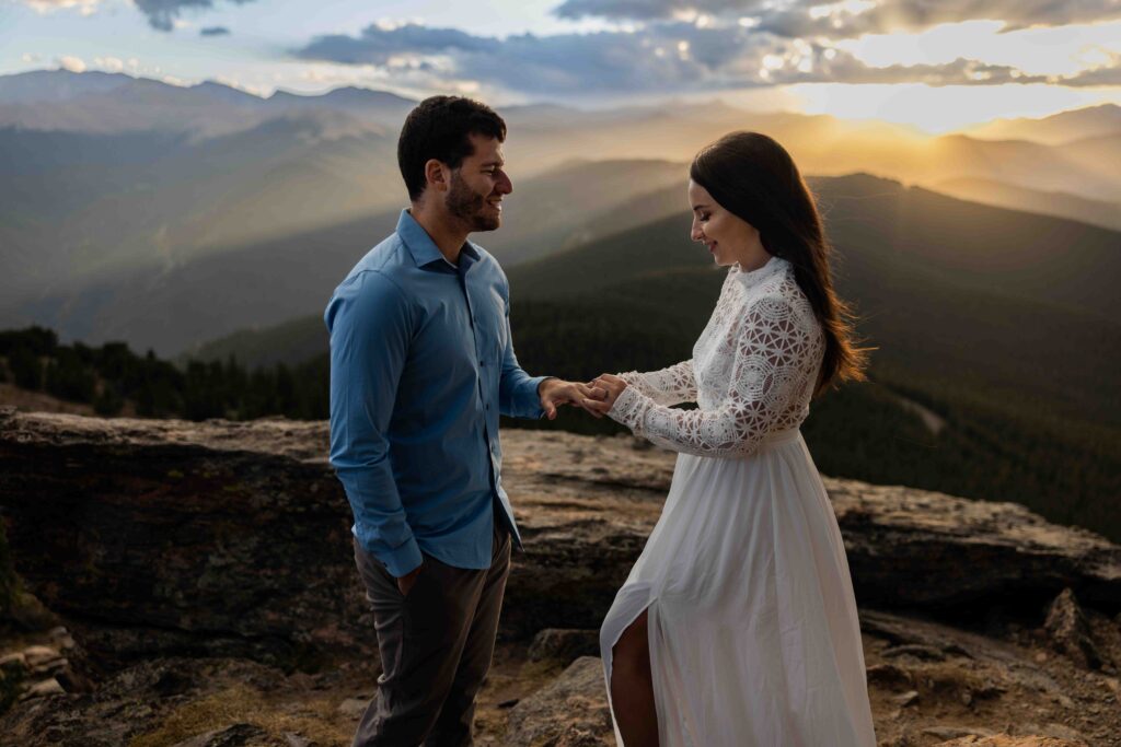 Bride and groom standing on the summit of Chief Mountain, exchanging vows with breathtaking mountain views.