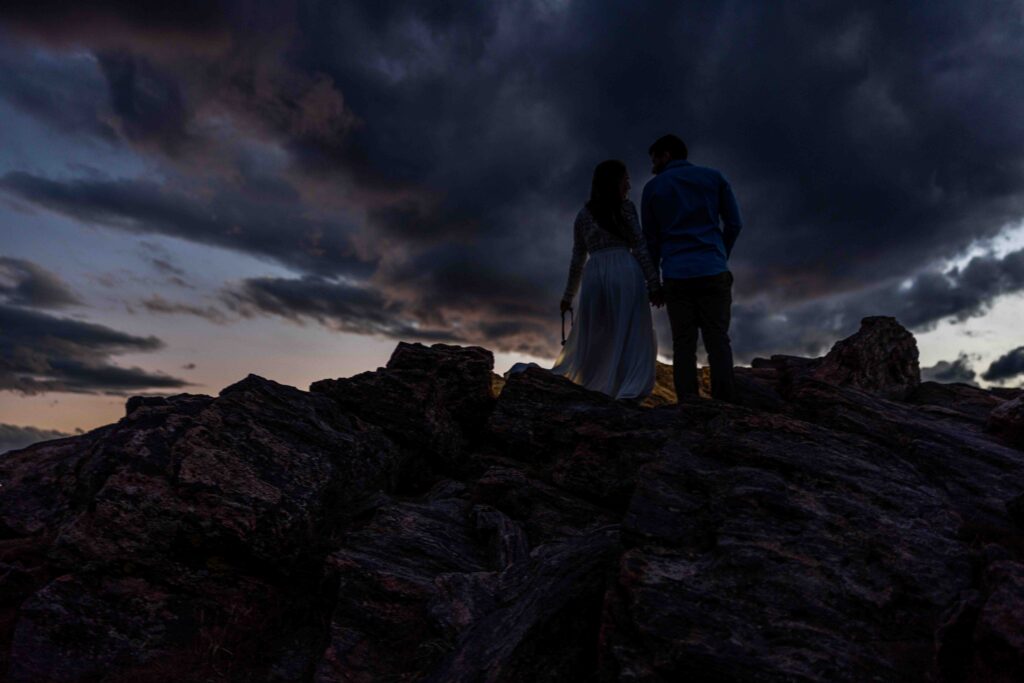 Couple walking hand-in-hand down the mountain trail, soaking in the moment.