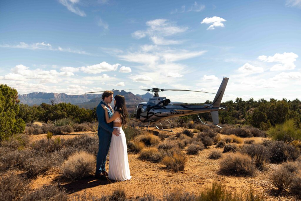 Wide-angle shot of the couple exchanging vows on a dramatic cliffside