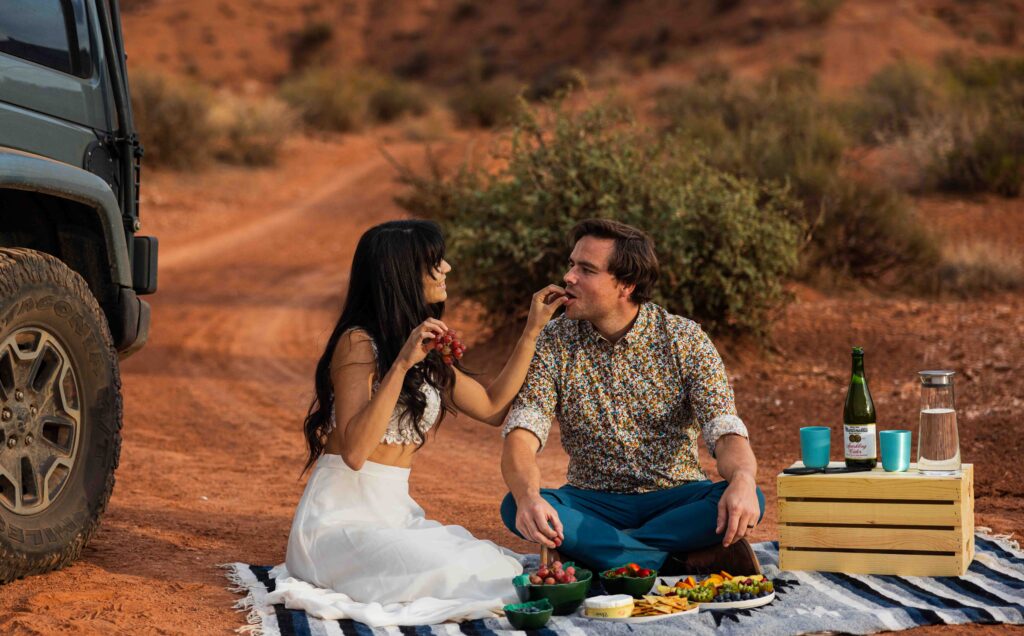 Candid shot of the couple embracing with the Jeep in the background