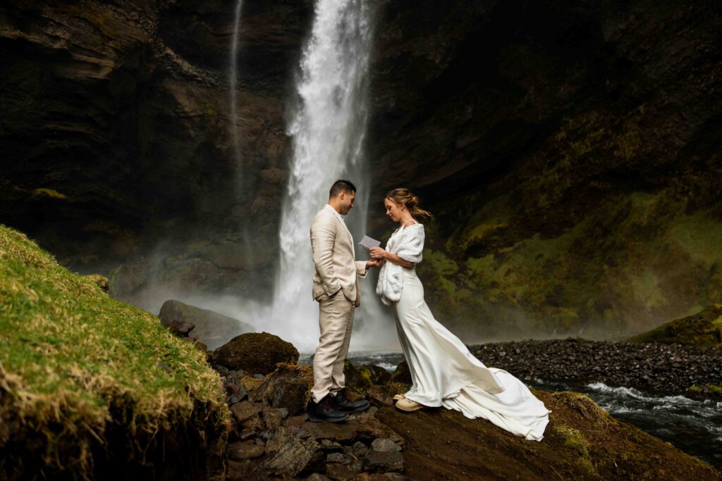 Aerial view of the couple exchanging vows in front of the waterfall