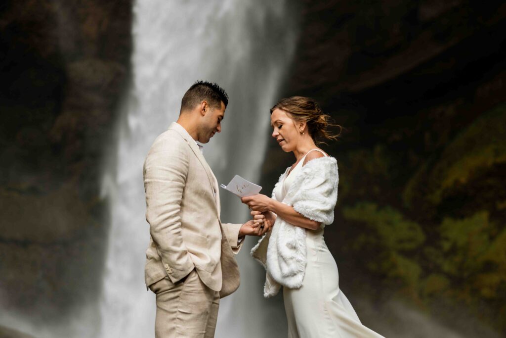 Groom helping the bride tie her shoes in their Airbnb before the elopement