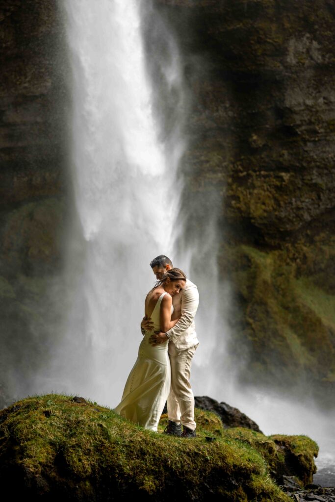 Couple walking hand in hand through a misty Icelandic valley