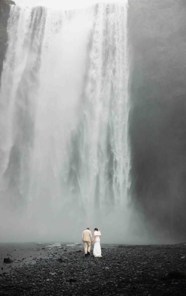 Bride and groom looking out over a vast Icelandic canyon