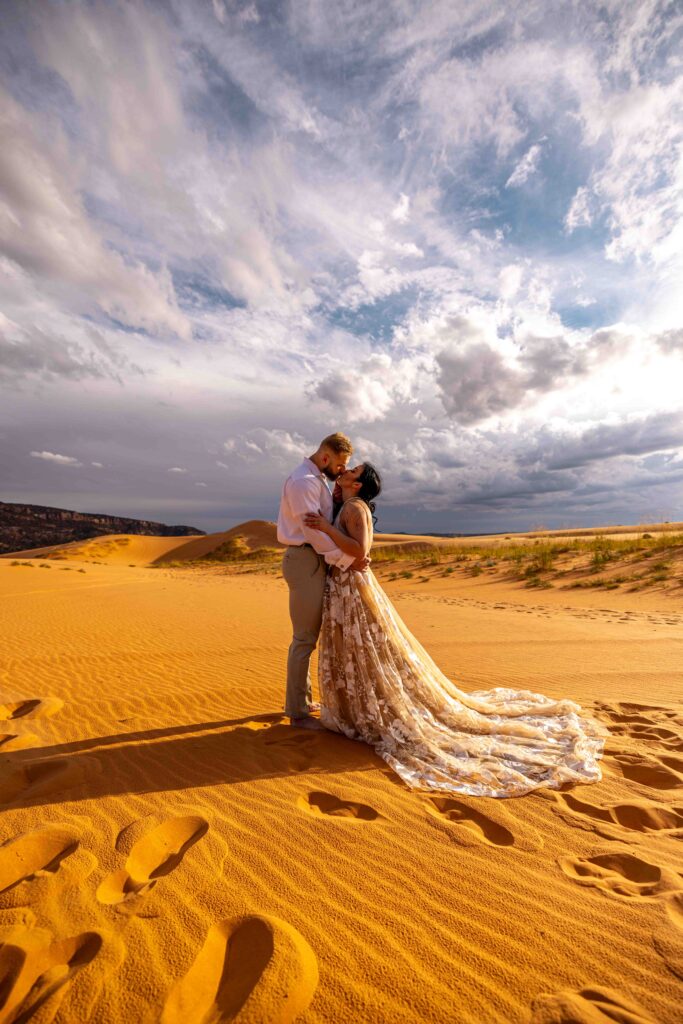 Two couples walking hand in hand through the Utah sand dunes at sunset