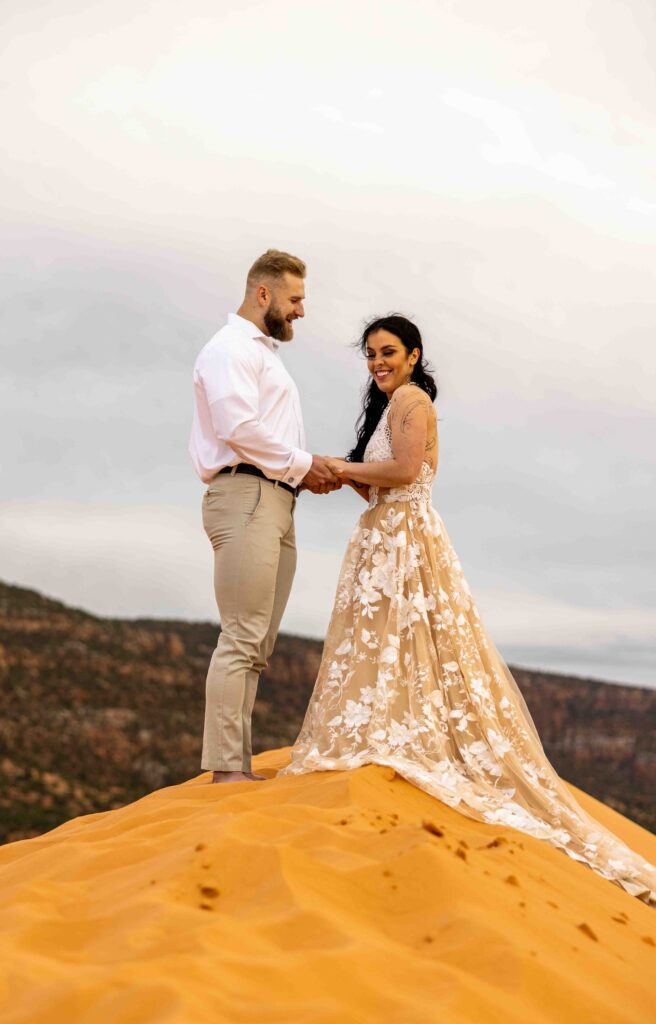 Final shot of the couples walking toward the horizon, hand in hand, with soft desert hues fading behind them