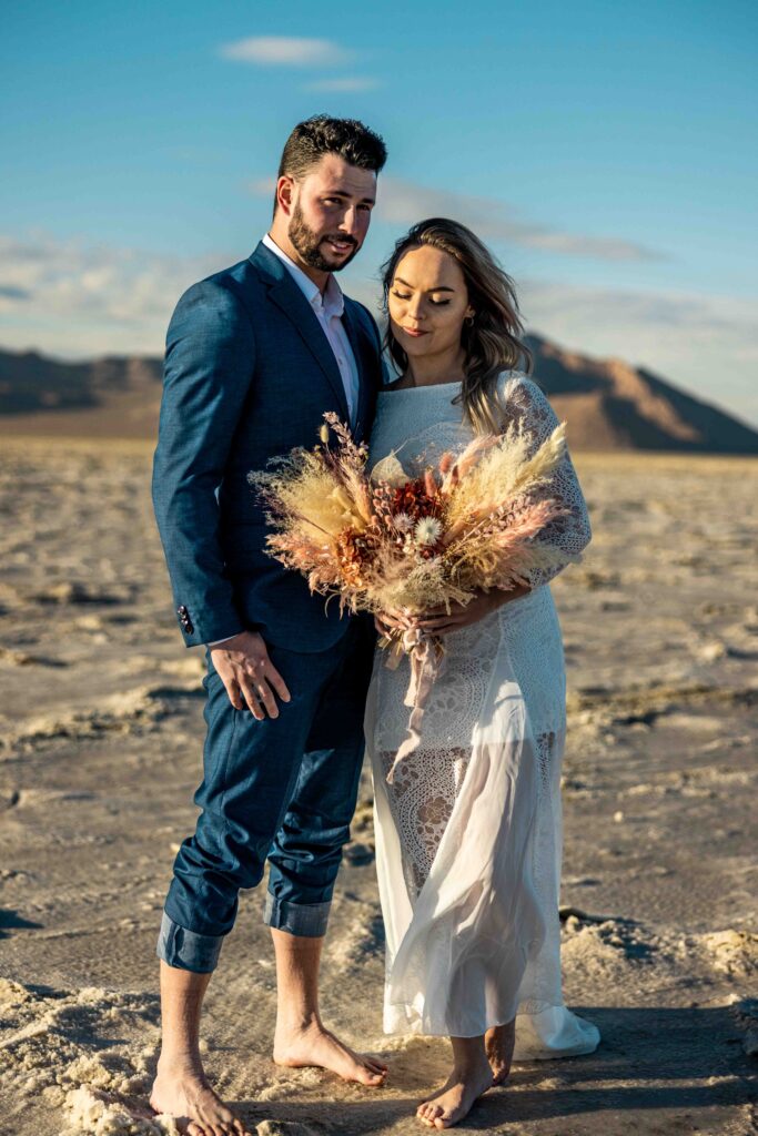 Couple walking hand in hand across the Bonneville Salt Flats at sunset