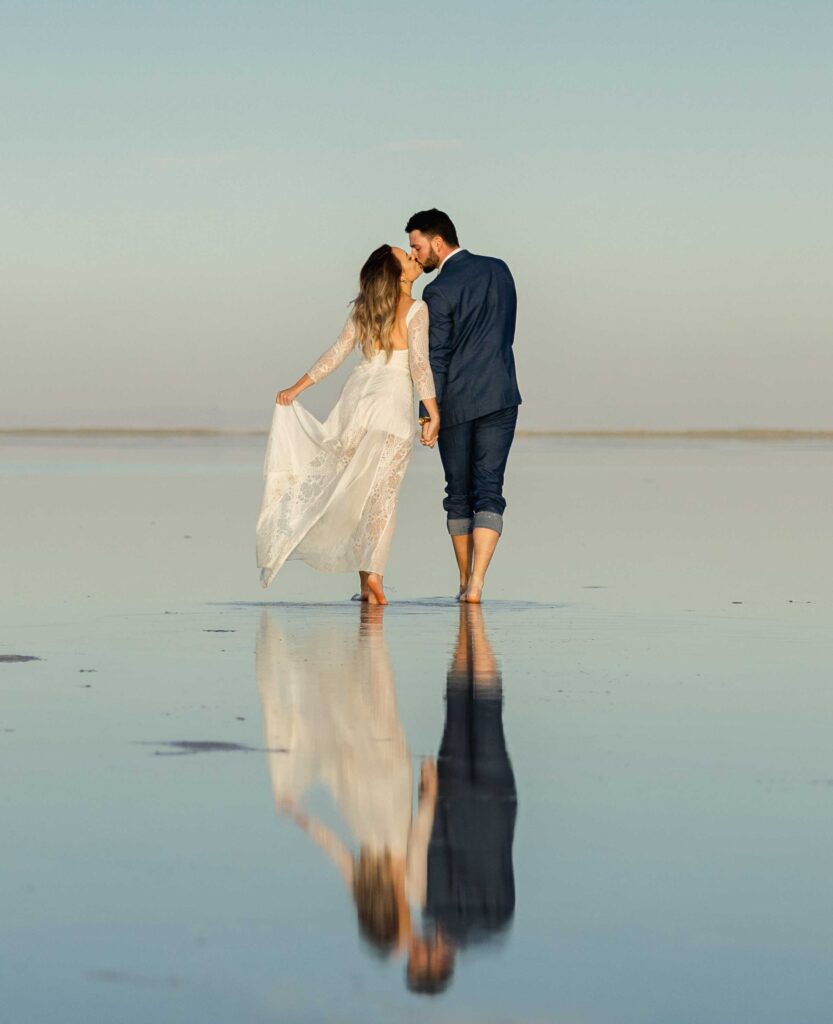 Bride and groom sharing a romantic kiss with a stunning backdrop