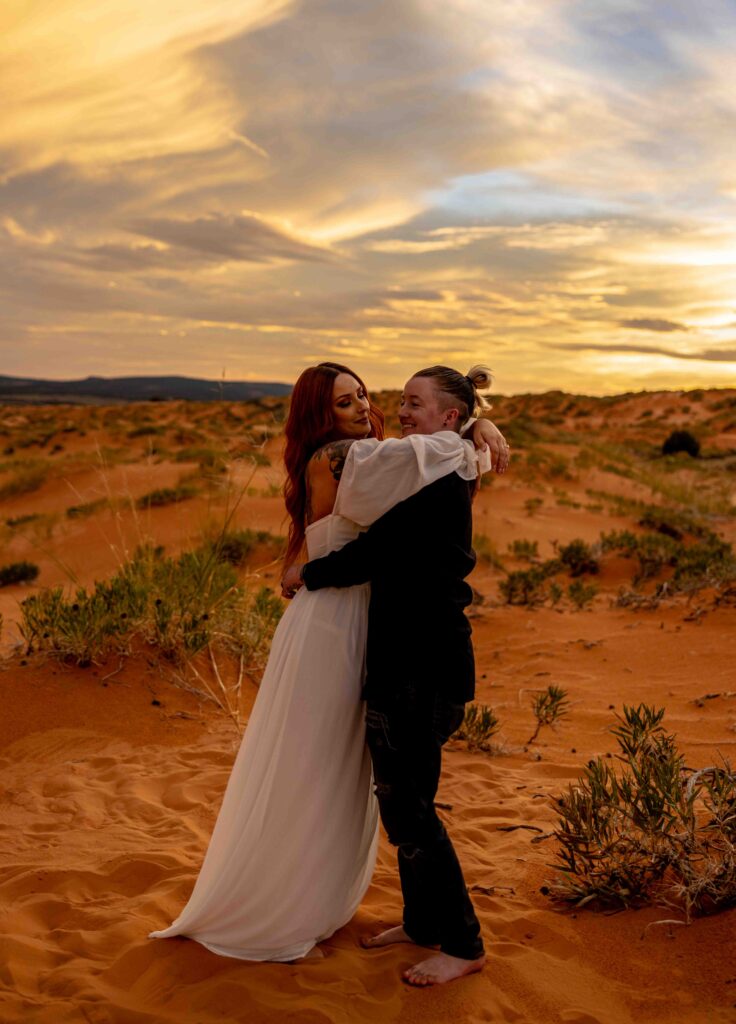 Bride and groom holding hands as they walk barefoot in the sand