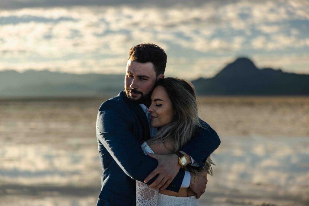 Groom adjusting his tie with the endless landscape behind him