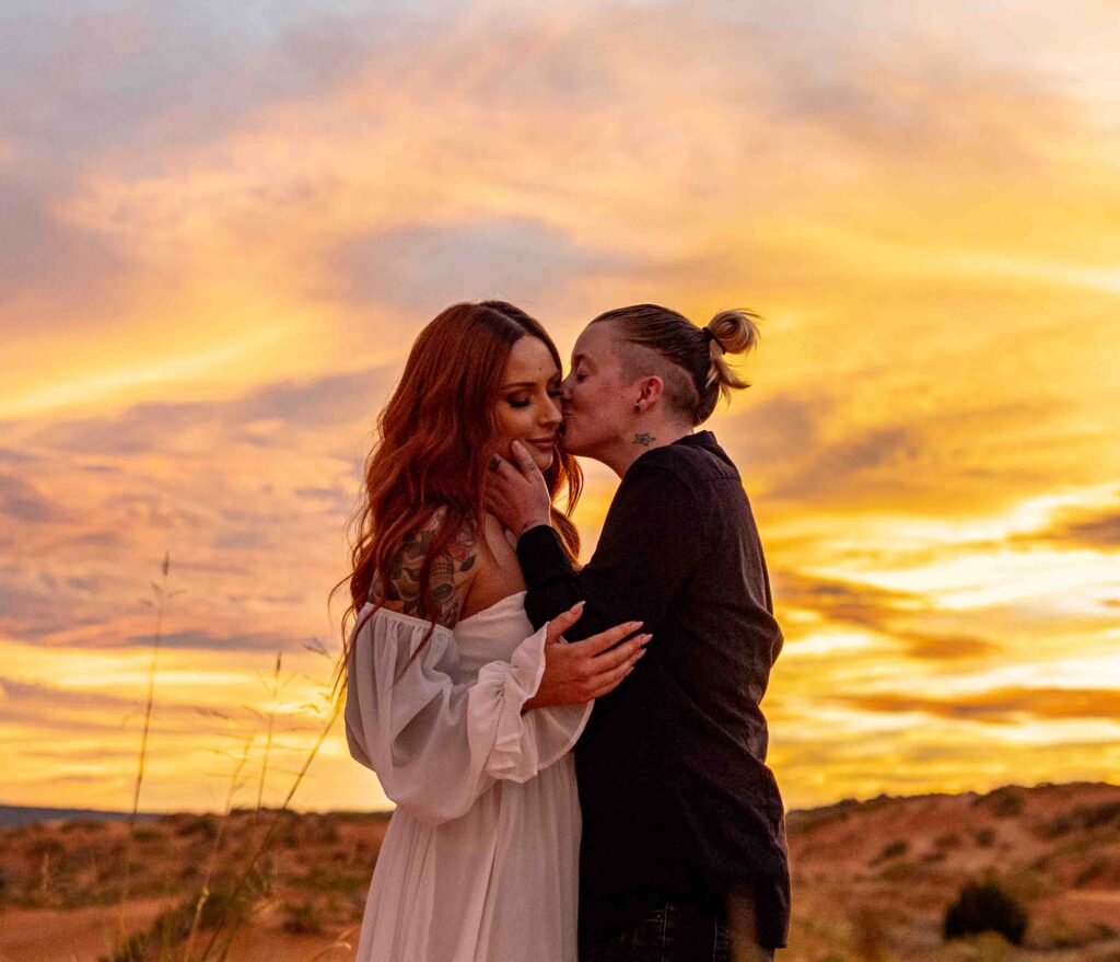 A joyful candid shot of the couples celebrating together in the dunes