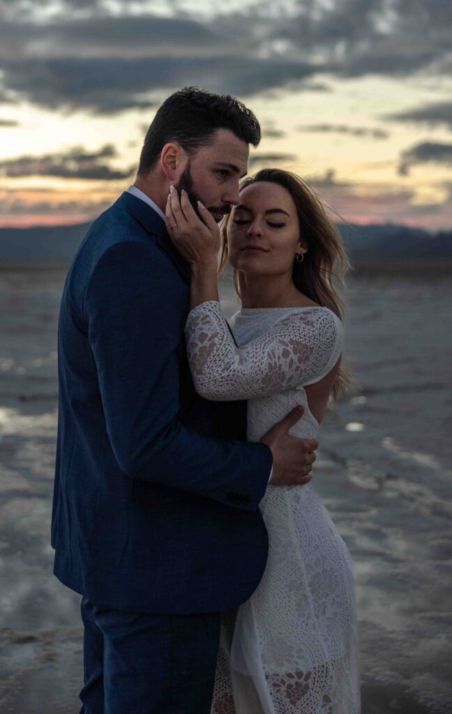 Couple wrapped in a blanket under the fading desert light