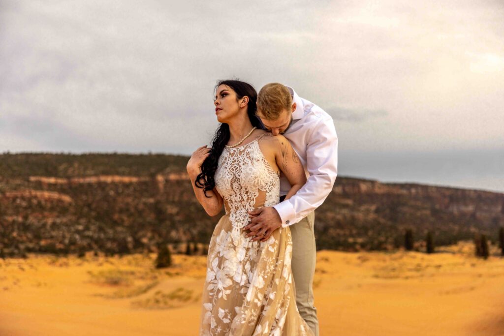 One couple lifting the other’s veil playfully in the wind