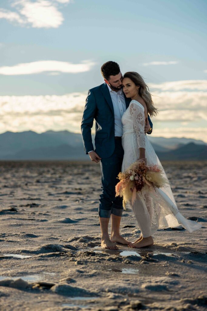 Bride’s dress flowing in the wind with the open landscape behind her