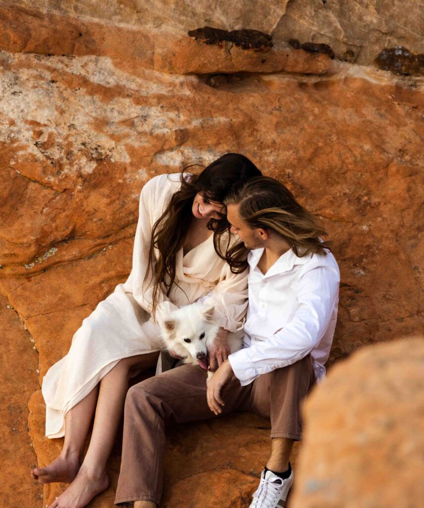 Groom securing climbing ropes with the vast Utah desert in the background.