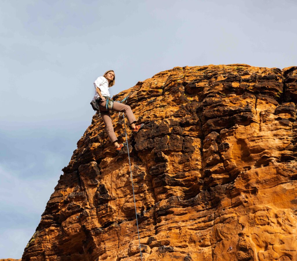 Bride and groom suspended in midair, holding hands while reading their vows with a 1,000-foot drop below.