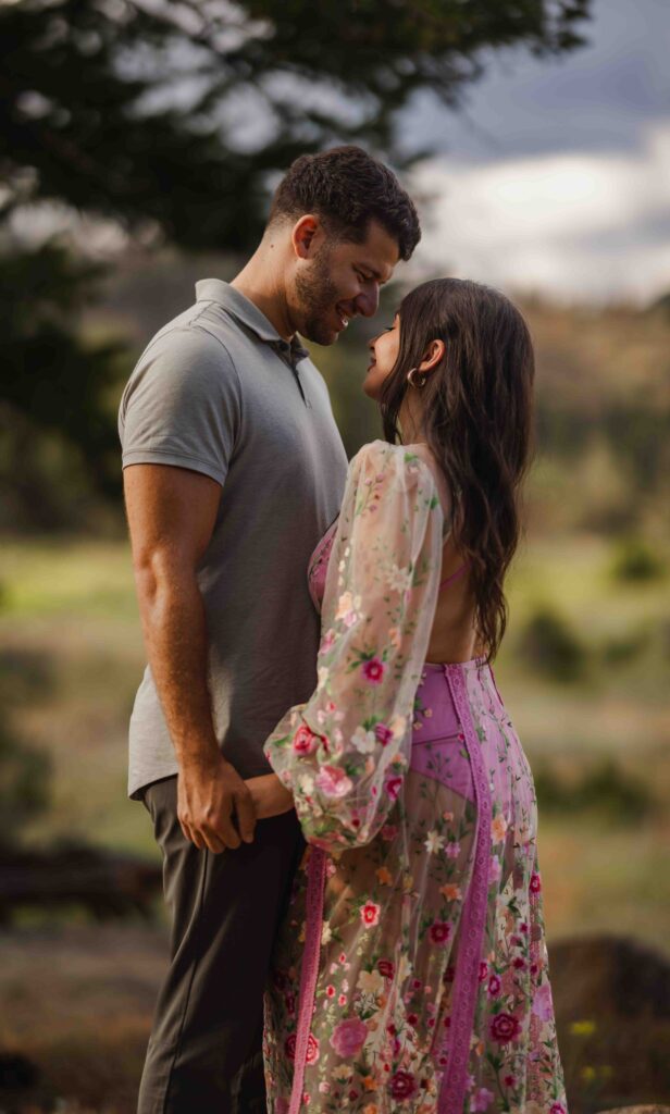 Wide shot of the couple with the mountain range behind them.