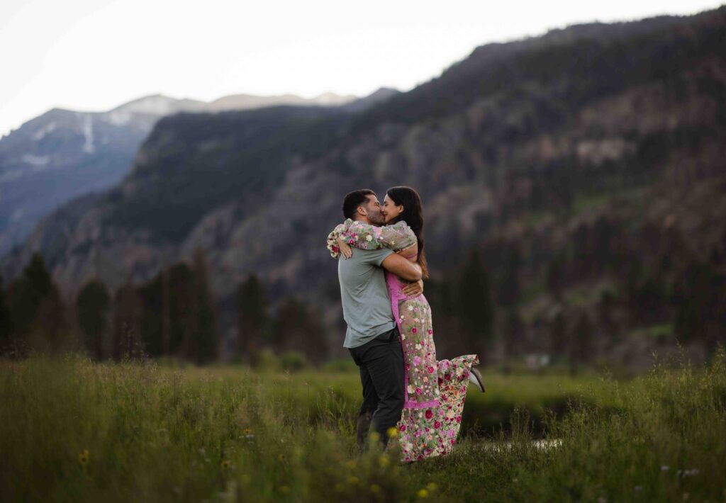 Wide landscape shot of the engaged couple standing in Moraine Park.