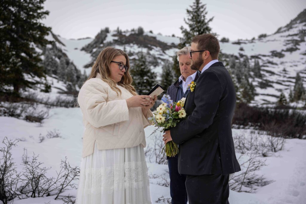 Bride and groom walking hand in hand through the mountain mist
