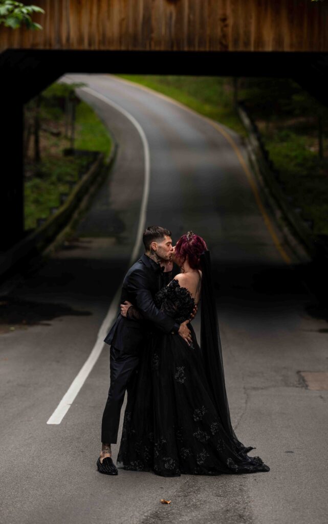 Couple sharing a sunset kiss with golden light glowing behind them
