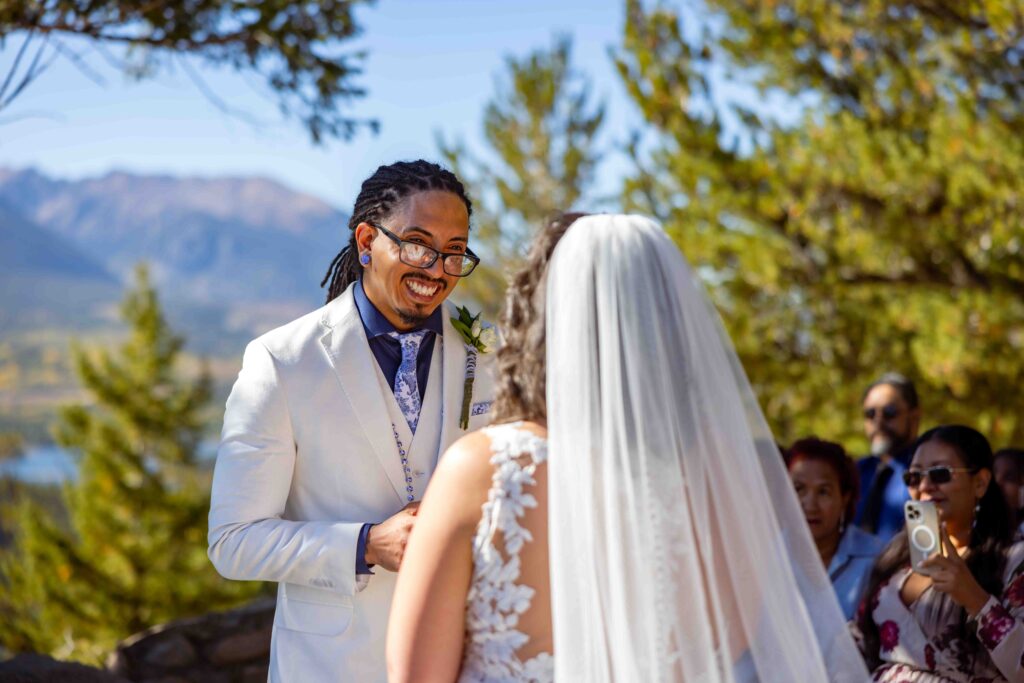 Romantic forehead kiss with the Rocky Mountains in the background.