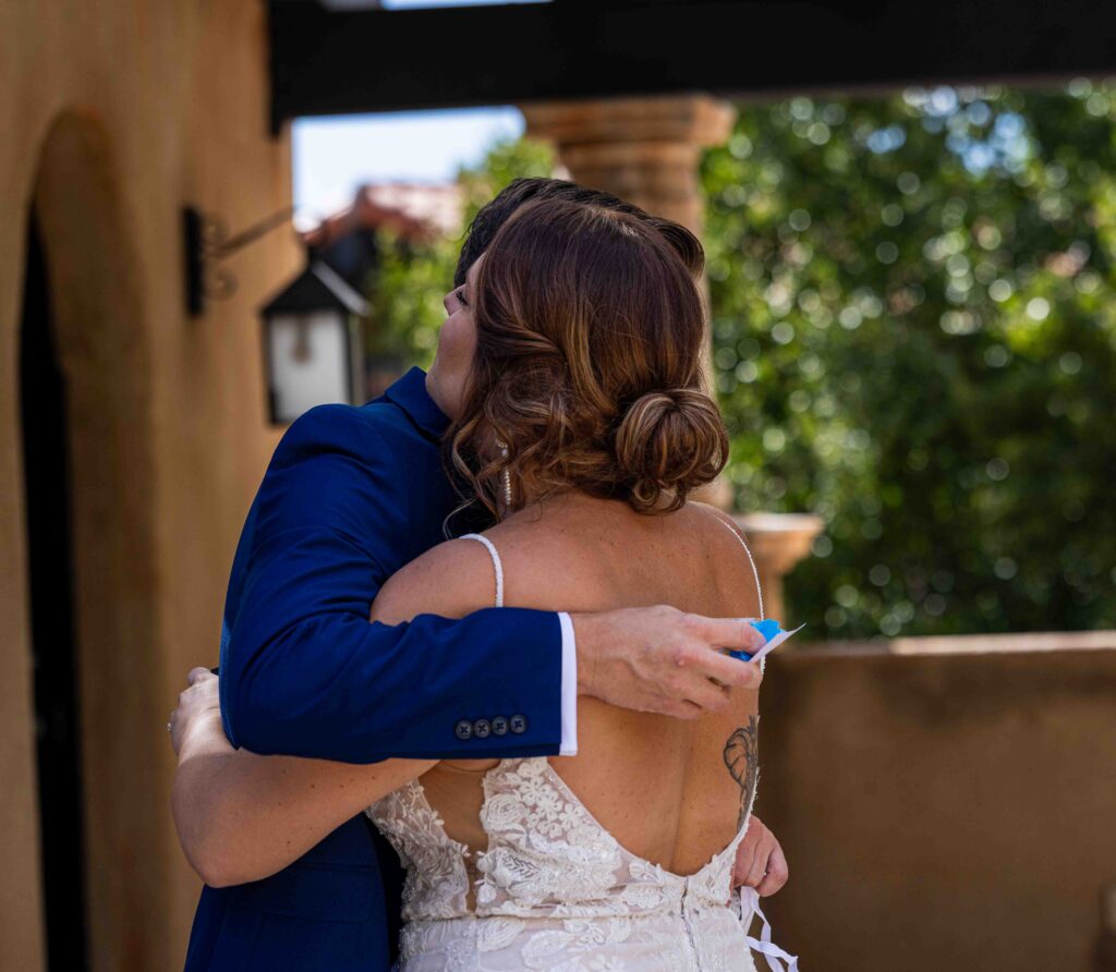 Bride stepping into her wedding dress with the help of a family member
