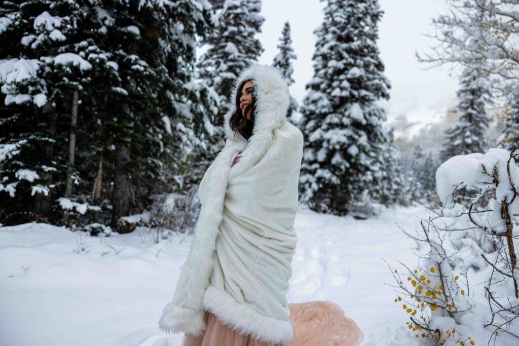 Groom lifting the bride in a playful embrace in the snow