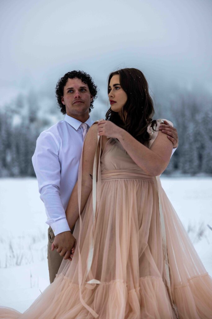 Snow-dusted pine trees framing the couple’s elopement journey